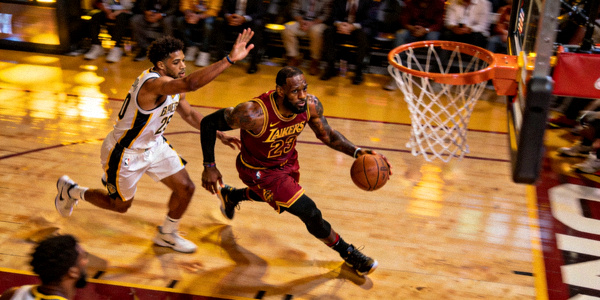 勒布朗詹姆斯在NBA比赛中突破上篮，防守球员紧随